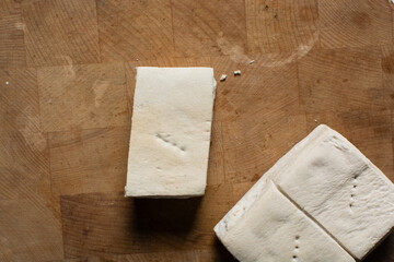 Overhead view of hardtack bread on a wood chopping board, top view of nigerian hardtack also known...