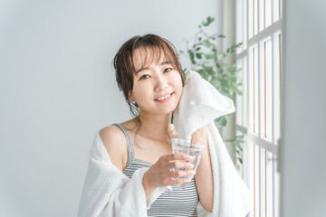 風呂上がり・トレーニング後に水を飲むアジア人女性（水分補給）
