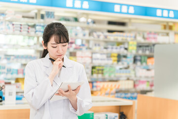薬局で働く薬剤師も女性（メモ・勉強・服薬指導）
