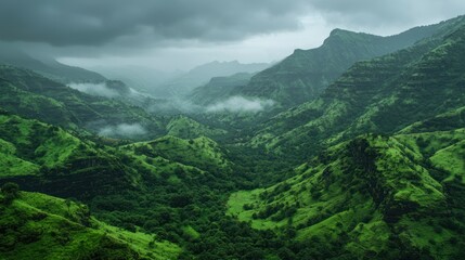 A vast mountain range with lush green valleys and misty peaks in the distance