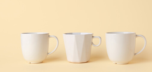 White ceramic empty mugs on beige background