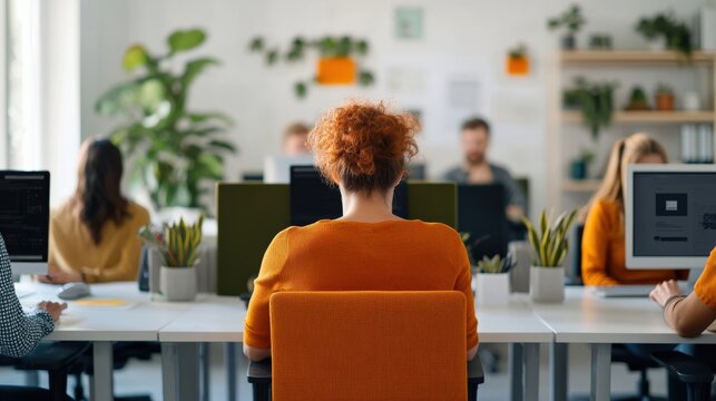 Focused Office Environment with Diverse Professionals Working at Desks Surrounded by Plants and Technology