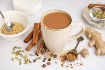 Cup of tasty masala tea with different spices on light background, closeup