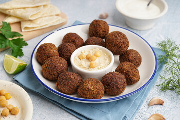 Plate with delicious falafel balls and hummus on light background, closeup