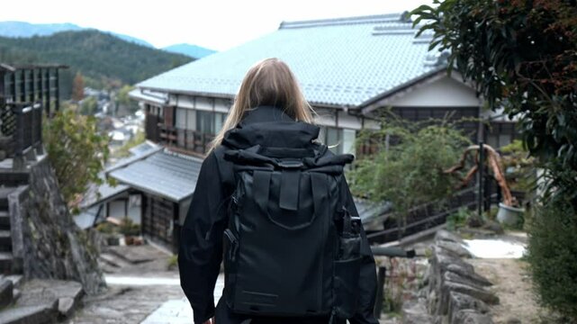 A serene stock video of a girl walking through the picturesque village of Magome, part of the historic Nakasendo Trail in Japan.