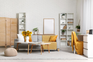 Vase with sunflowers on coffee table in stylish living room