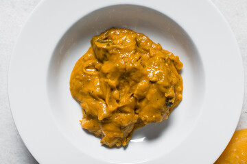Overhead view of Nigerian owo soup with fish and beef in a white plate, top view of oghwo soup in a large dinner plate, traditional owo soup in a white dish