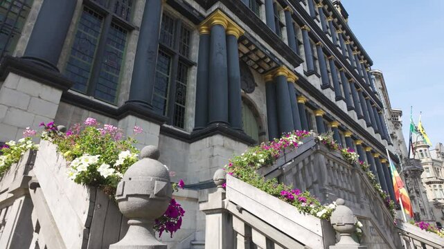 A historic City Hall in Ghent, Belgium, with floral-decorated staircases in sunlight