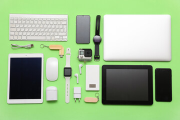 Set of modern devices on green background, top view