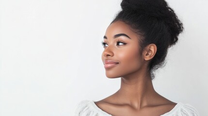 Thoughtful young woman with curly hair gazing to the side against a white studio backdrop expressing contemplation and beauty