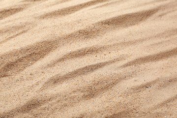 Beach sand with waves as background, closeup