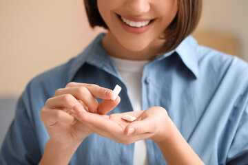 Young woman with chewing gums at home, closeup