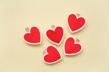 Heart shaped decorations with clothespins on beige background. Valentine's Day celebration