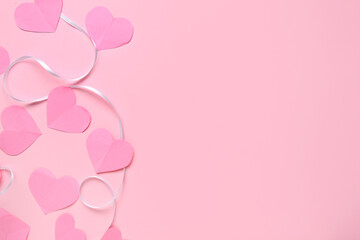 Ribbon with paper hearts on pink background. Valentine's Day celebration