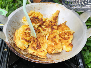 The omelet is half-fried, then cut into pieces.