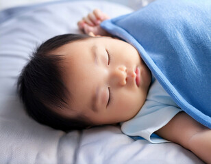 ベビーベッドに横たわり毛布をかけて眠る新生児の赤ちゃん　育児・成長・子育てのイメージ