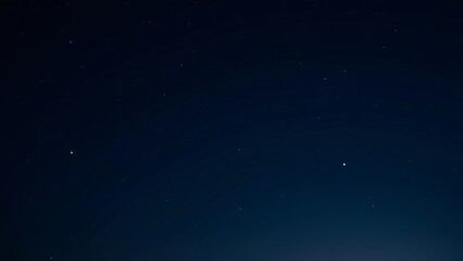 A moonless sky with stars forming subtle, intricate patterns across the dark expanse.