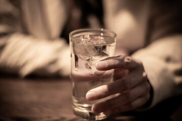 コップに注がれた水を持っている人