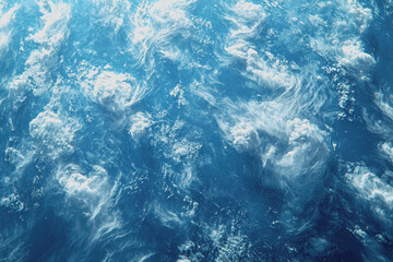 Fototapeta premium Aerial view of a serene ocean with waves and coastline visible from an airplane window during a bright sunny day