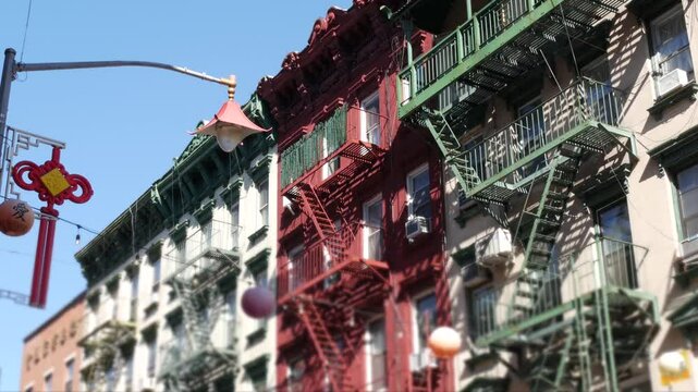 New York City, United States. Manhattan Chinatown Mott street, chinese ethnic district buildings architecture, USA. American red brick house in little China. Fire escape ladder in NYC. Paper lanterns.