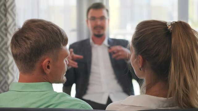 Selective focus on the family psychologist helping the couple seated on the couch, guiding them through the aftermath of stressful events and restoring emotional balance in their relationship.