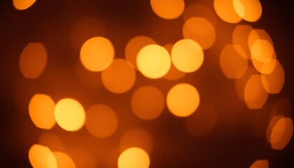 Obraz premium Golden bokeh lights with a warm glow, defocused circles creating a festive ambiance in soft orange and yellow tones.