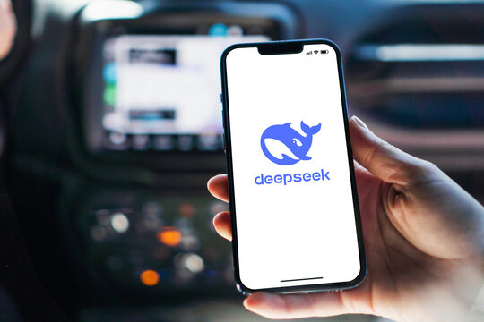Girl inside car holding smartphone with Deepseek artificial intelligence chatbot app on iPhone screen. Rio de Janeiro, RJ, Brazil. January 28 2025