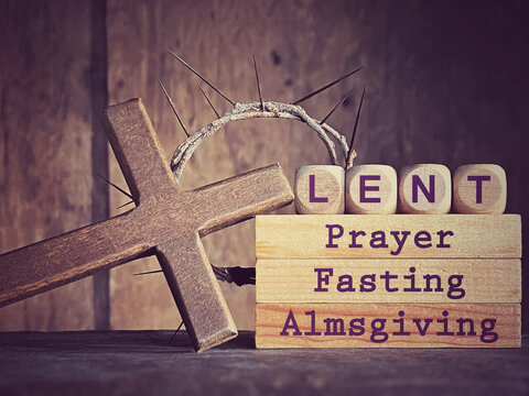 'Lent prayer fasting almsgiving' text on wooden blocks in purple vintage background. Stock photo.