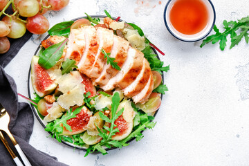 Delicious lunch with chicken, figs, cheese, grape and herbs. White background, top view