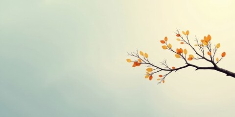Serene autumn branch with amber and gold leaves against a pale sky, a minimalist nature scene.