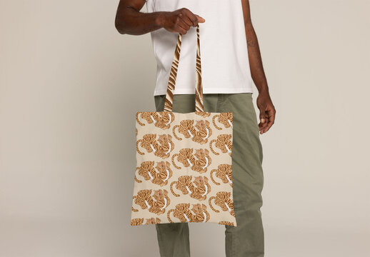 Black anonymous man holding tote bag for mockup