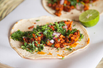 Delicious Mexican tacos with handmade tortillas with red pork chorizo and spicy green sauce.
