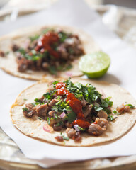 Delicious Mexican tacos with handmade tortillas with beef and spicy red sauce.