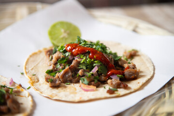 Delicious Mexican tacos with handmade tortillas with beef and spicy red sauce.