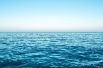Obraz premium Tranquil ocean view with gentle waves under a clear blue sky, evoking serenity and peace