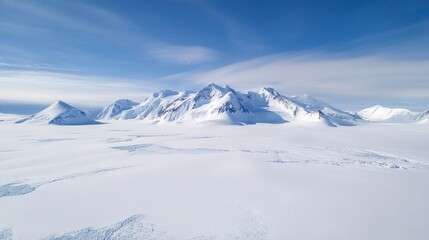 Obraz premium Panoramic view of snow-covered mountains and vast Antarctic plains under a clear blue sky.