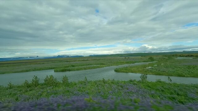 Travelling along vast green lava fields in Iceland punctuated with many rivers and streams