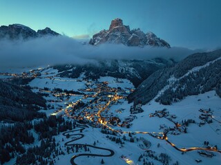 Aerial drone view of the Corvara village covered in snow