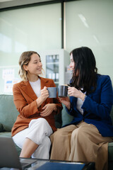 Obraz premium Two women collaborating on a project on sofa at home, brainstorming with a laptop and notebook