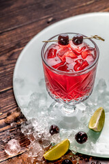Luxury cherry cocktail in crystal glass on wooden table