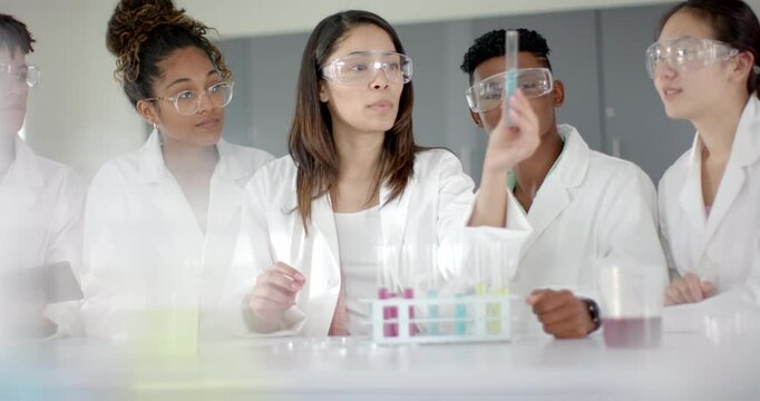 Five teenagers in lab coats are conducting an experiment in high school