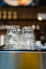 Clean shot glass lie upside down on a coffee machine in a cafe.