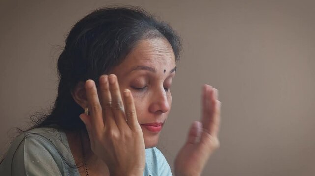 A young Indian Woman is crying. A young actor is doing crying acting in camera in studio light. 