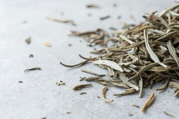 Close-up of dried white tea leaves on grey, serene landscape, detailed texture