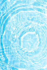 Blue water with ripples on the surface. Defocus blurred transparent blue colored clear calm water surface texture with splashes and bubbles. Water waves with shining pattern texture background.