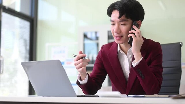 Young Businessman using laptop and tablet while sitting at her working place