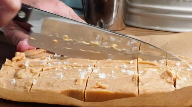 Making peanut butter fudge for a sweet treat.  Made with ingredients such as peanut butter, confectionery sugar, butter and topped with chocolate candy pieces.  No bake peanut butter dessert.