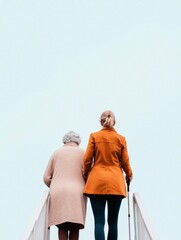 Fototapeta premium Soft Morning Care Young Female Caregiver Assisting Grandmother on Stairs - Urban Wellness Design and Family Support in Sustainable Living Spaces