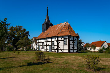 Auf einem freien Feld in der Ortsmitte steht die denkmalgeschützte historische Fachwerkkirche Dümde