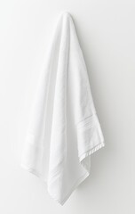 Fototapeta premium White bath towel hanging on a hook against a white wall. (1)